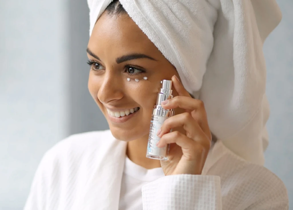 woman putting lotion on her face