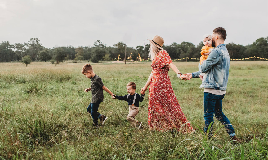 Family walking outside in tall grass