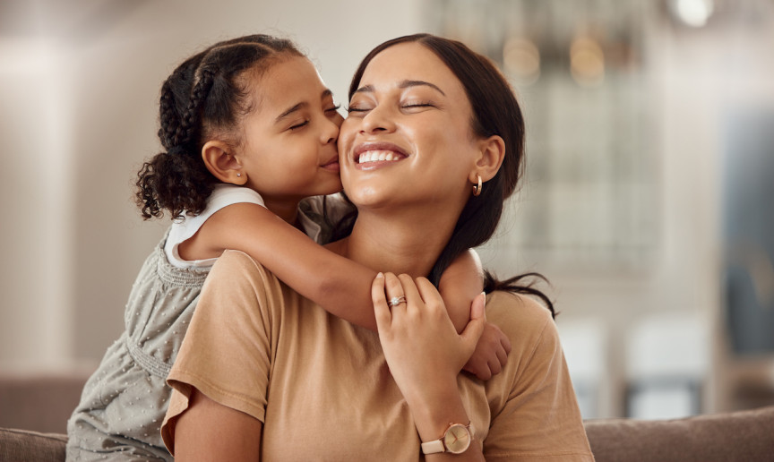 mother being kissed by daughter